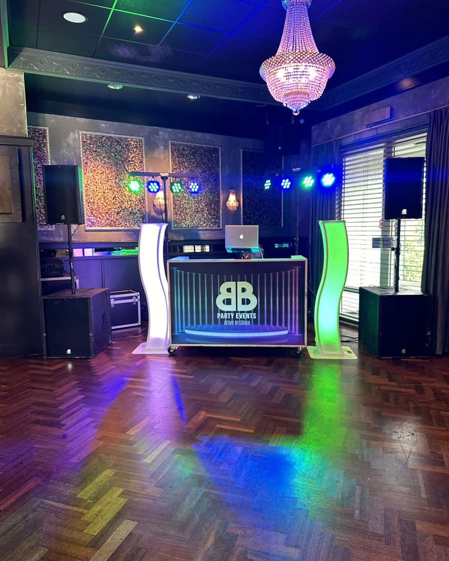 DJ-booth met kroonluchter en blauw-groene lichtshow