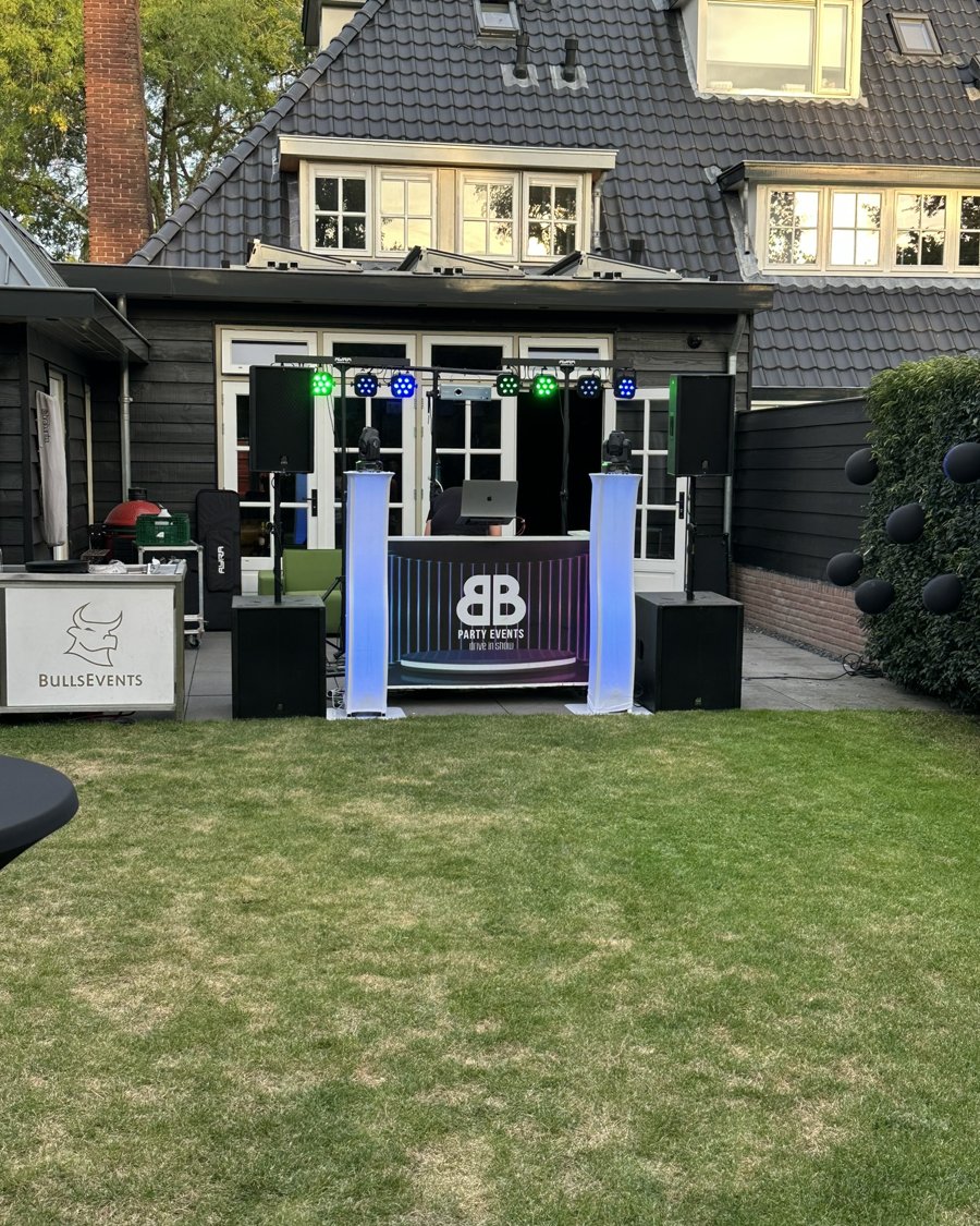 DJ-booth in tuin met blauw-groene lichtshow