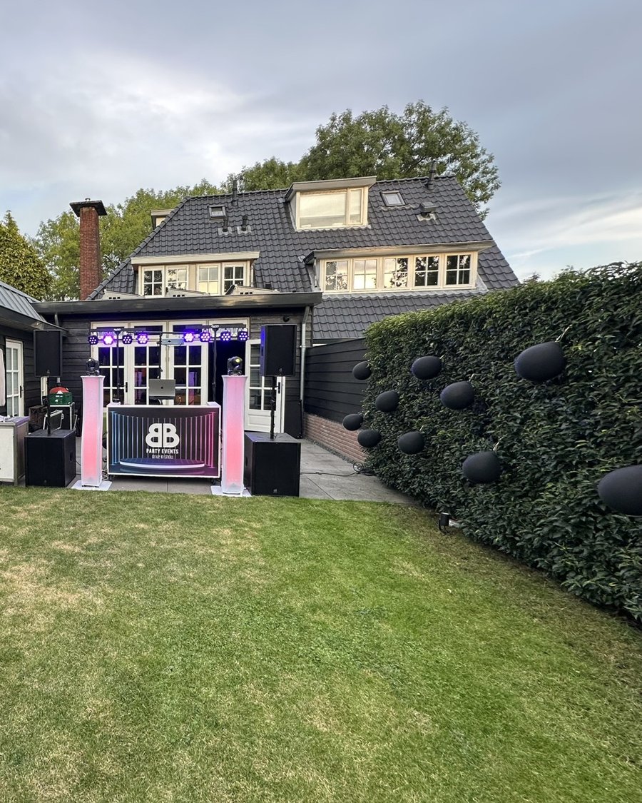 DJ-booth in tuin met roze verlichting